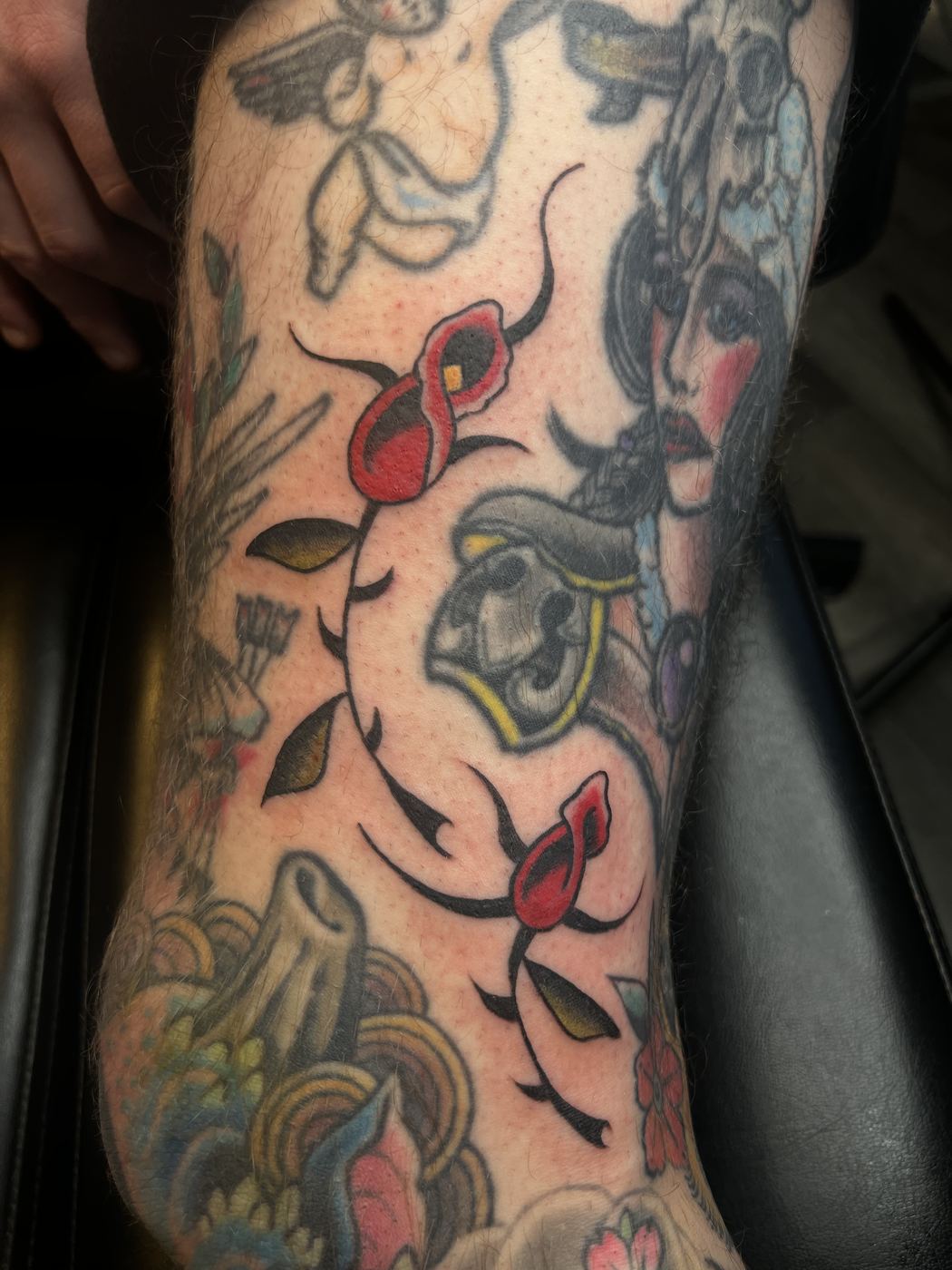 Color sleeve tattoo featuring a thorned rose, a skull in a cowboy hat, and a woman&rsquo;s portrait